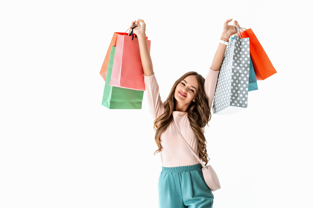 A girl holding up a bunch of shopping bags